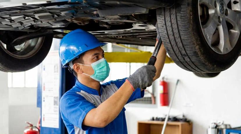 Seorang teknisi sedang melakukan spooring balancing